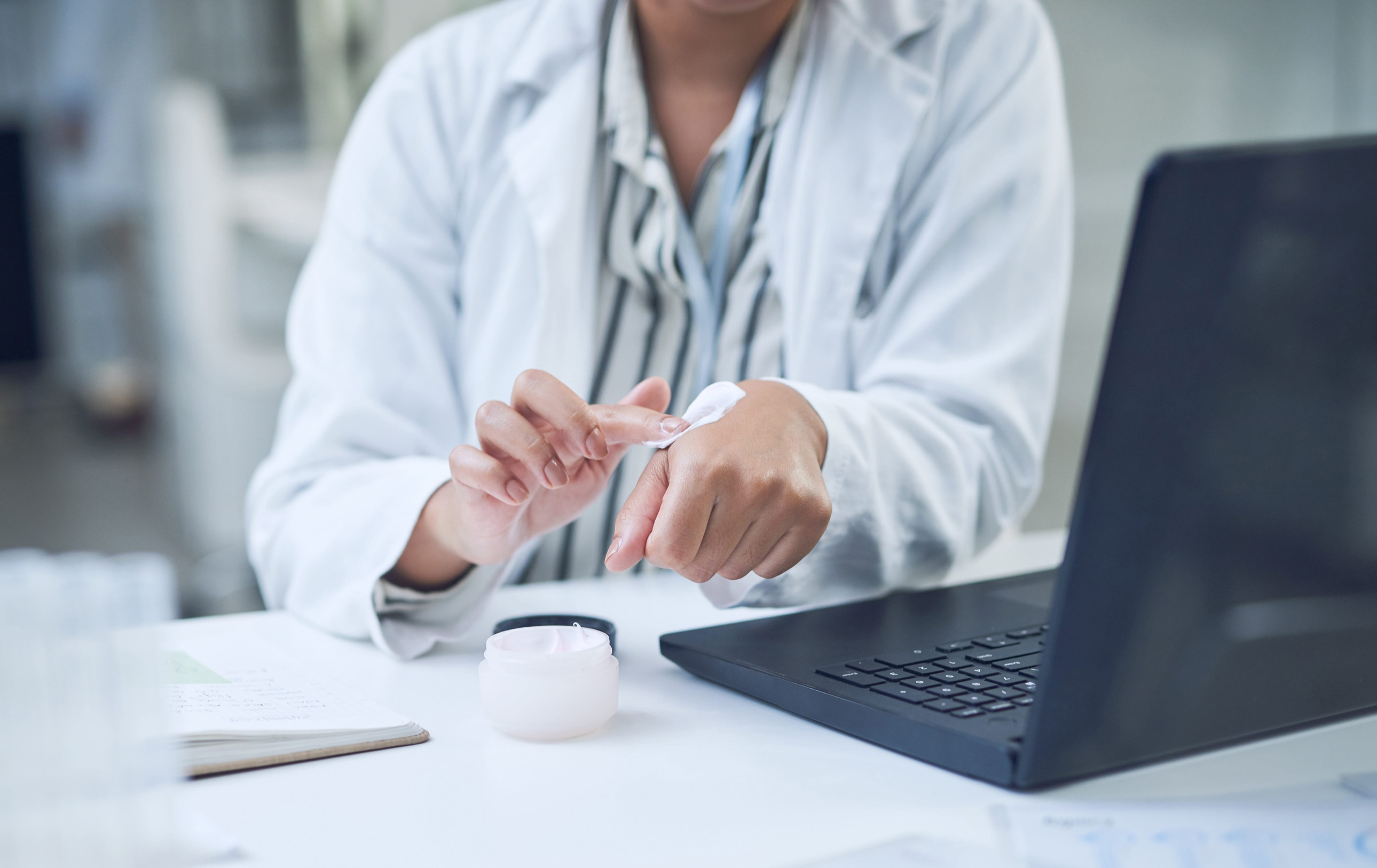 Pharmacist applying topical cream for dermatology compounding